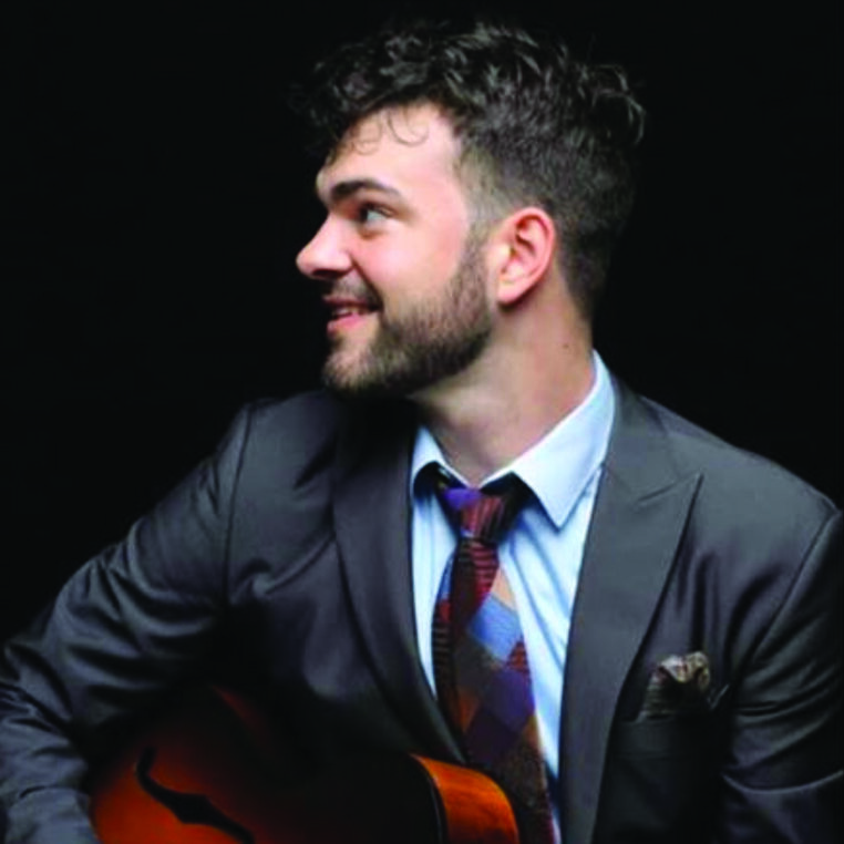 a headshot of guitarist Andrew Latona for his live performance at the Roxy bar