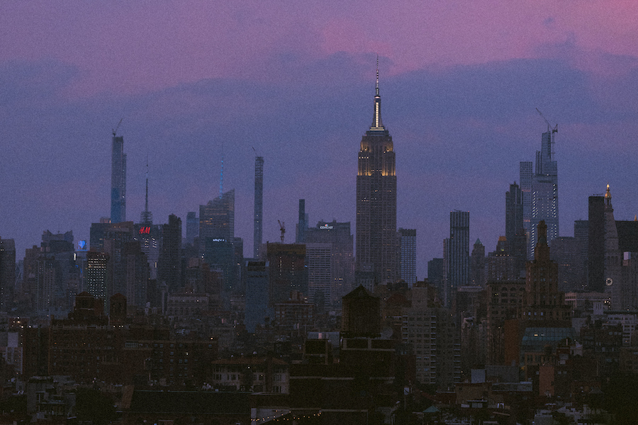 Landscape of tall buildings as the sky sets a violet purple