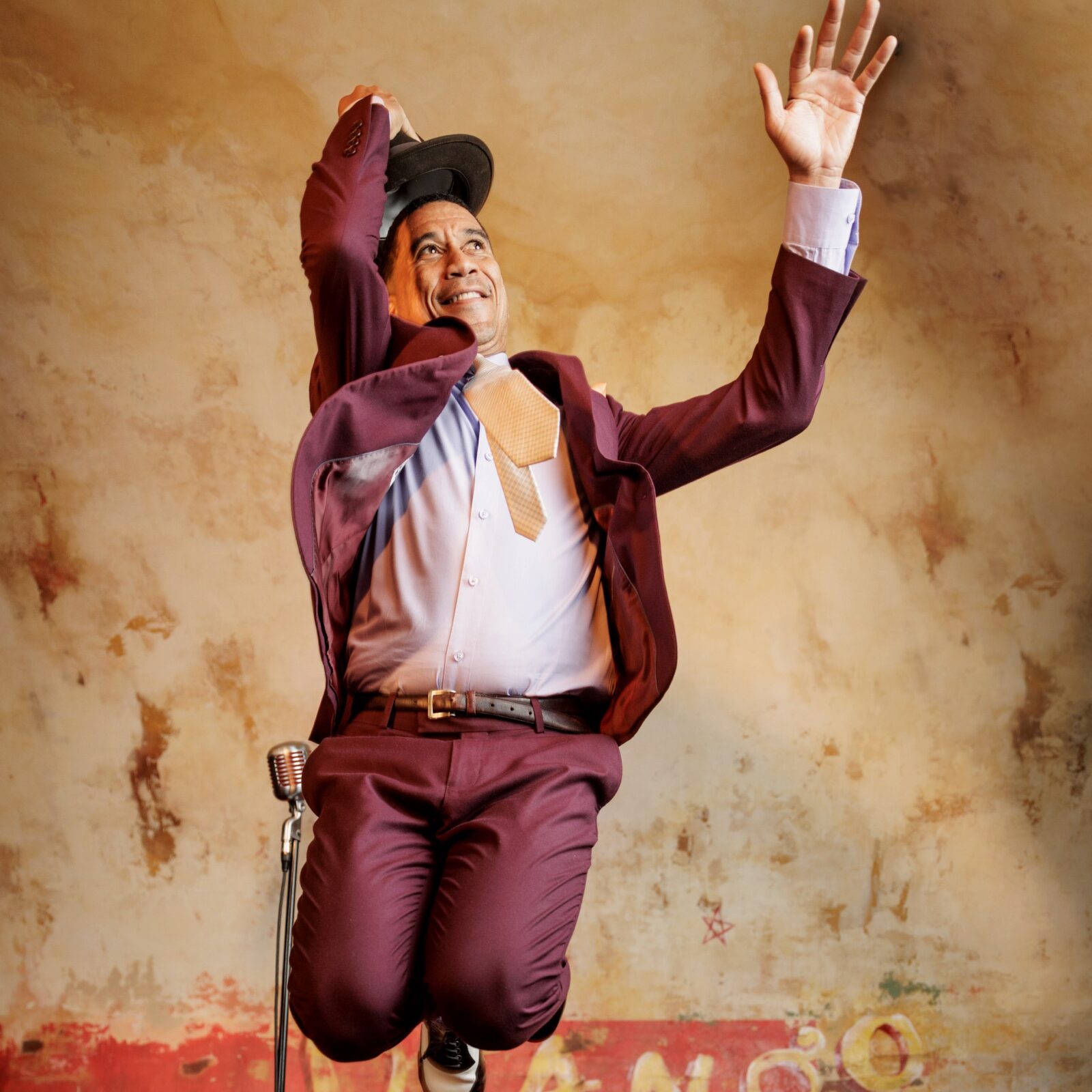 Musician Chino Pons jumping on the stage during a performance.