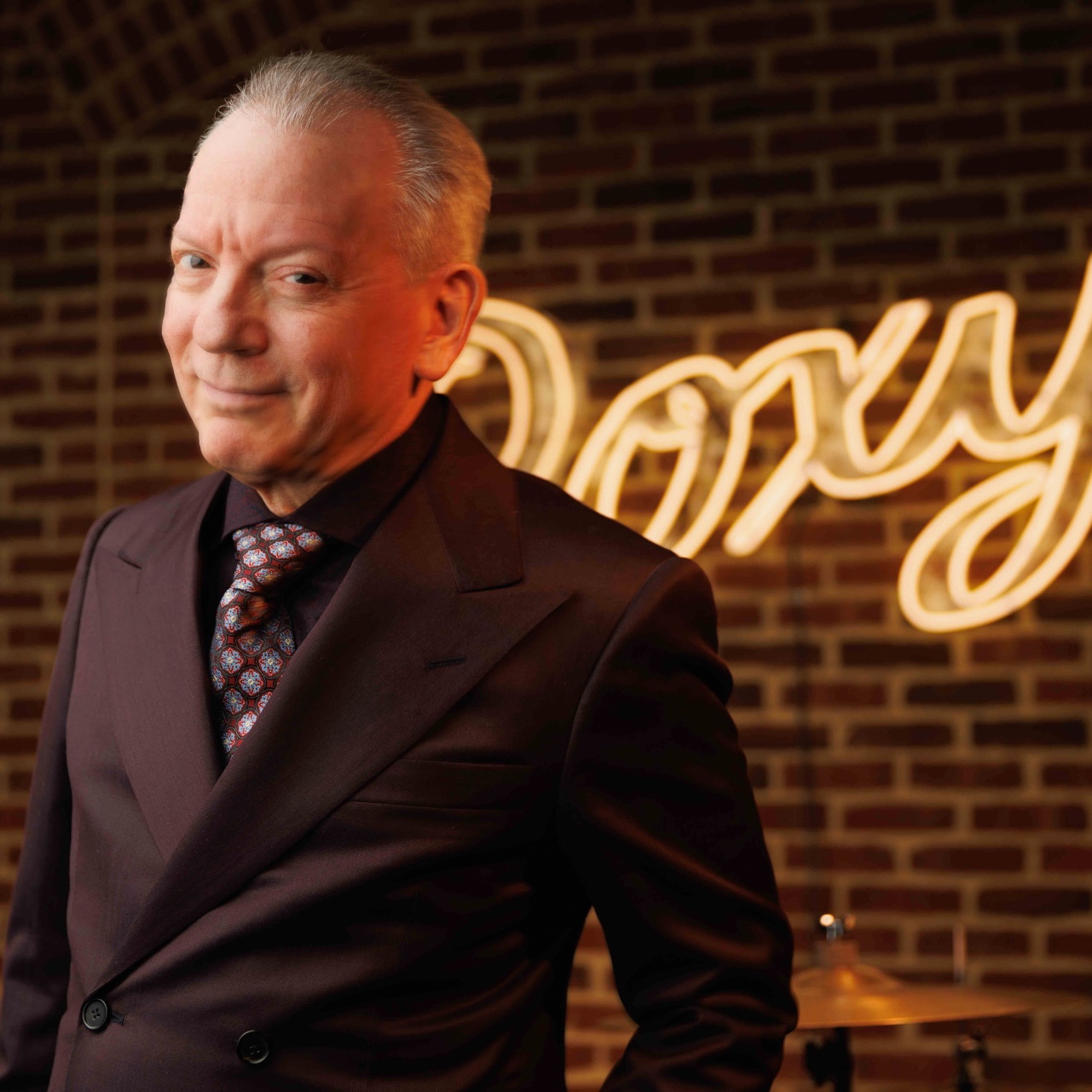 Musician Michael Garin standing in front of The Roxy neon stage sign.