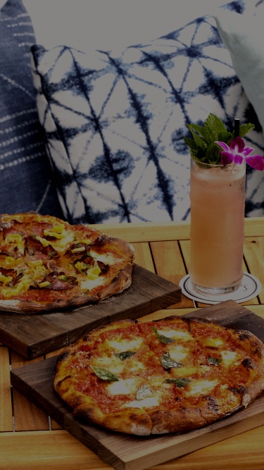 Two pizzas on a table at Gilligan's.