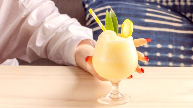 Woman holding the Limoncello Pina Colada at Gilligan's Outdoor Restaurant and Bar in SoHo, NY.