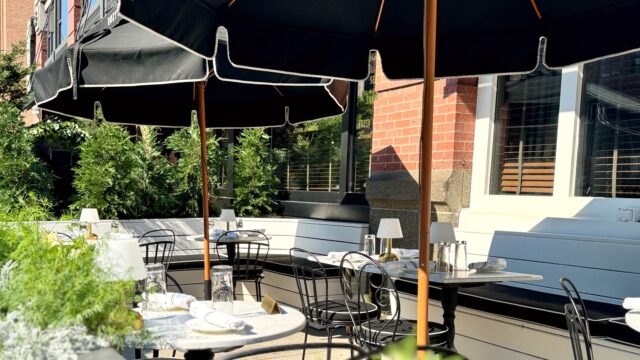 Outdoor dining table setup with black umbrellas at Roxy Café.