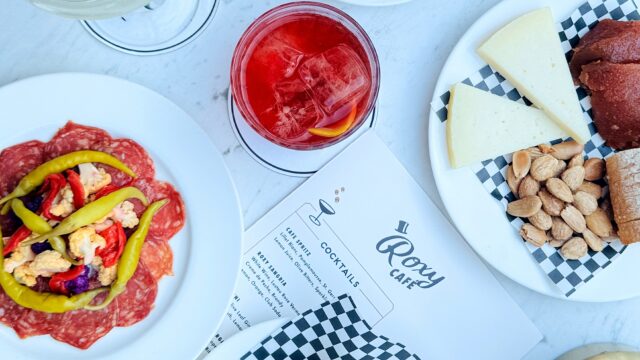 Tapas and cocktails on an outdoor white marble table at Roxy Café.