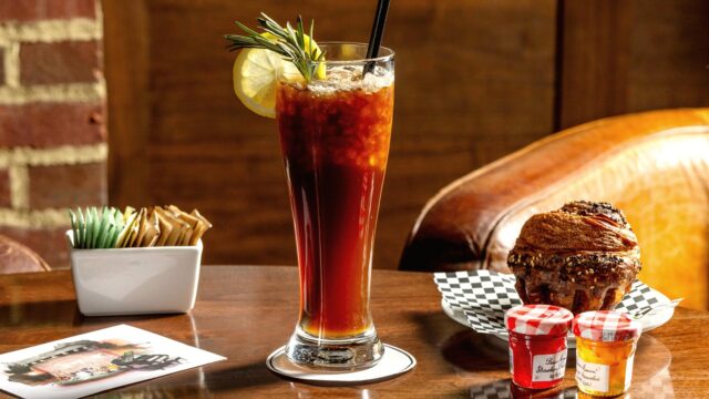 Roxy Café TriBeCa specialty cafe menu items including a layered iced espresso drink with a straw, fresh baked goods, and condiments on the border of SoHo.