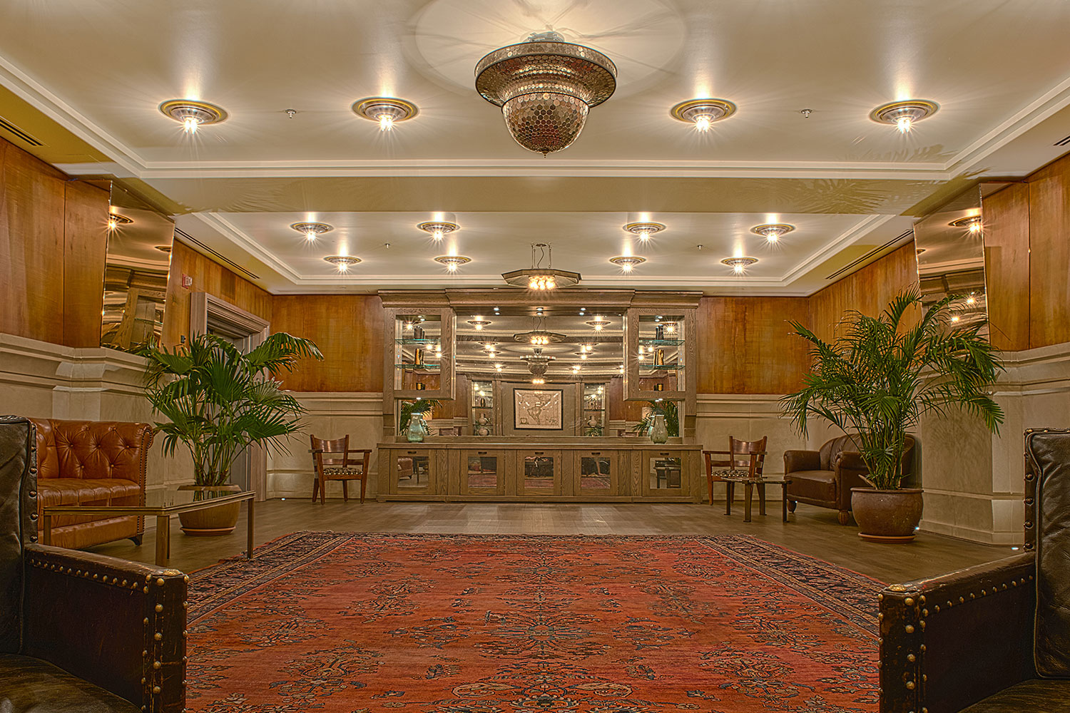 luxe ballroom with a disco ball, a bar and a palm trees flanking the space