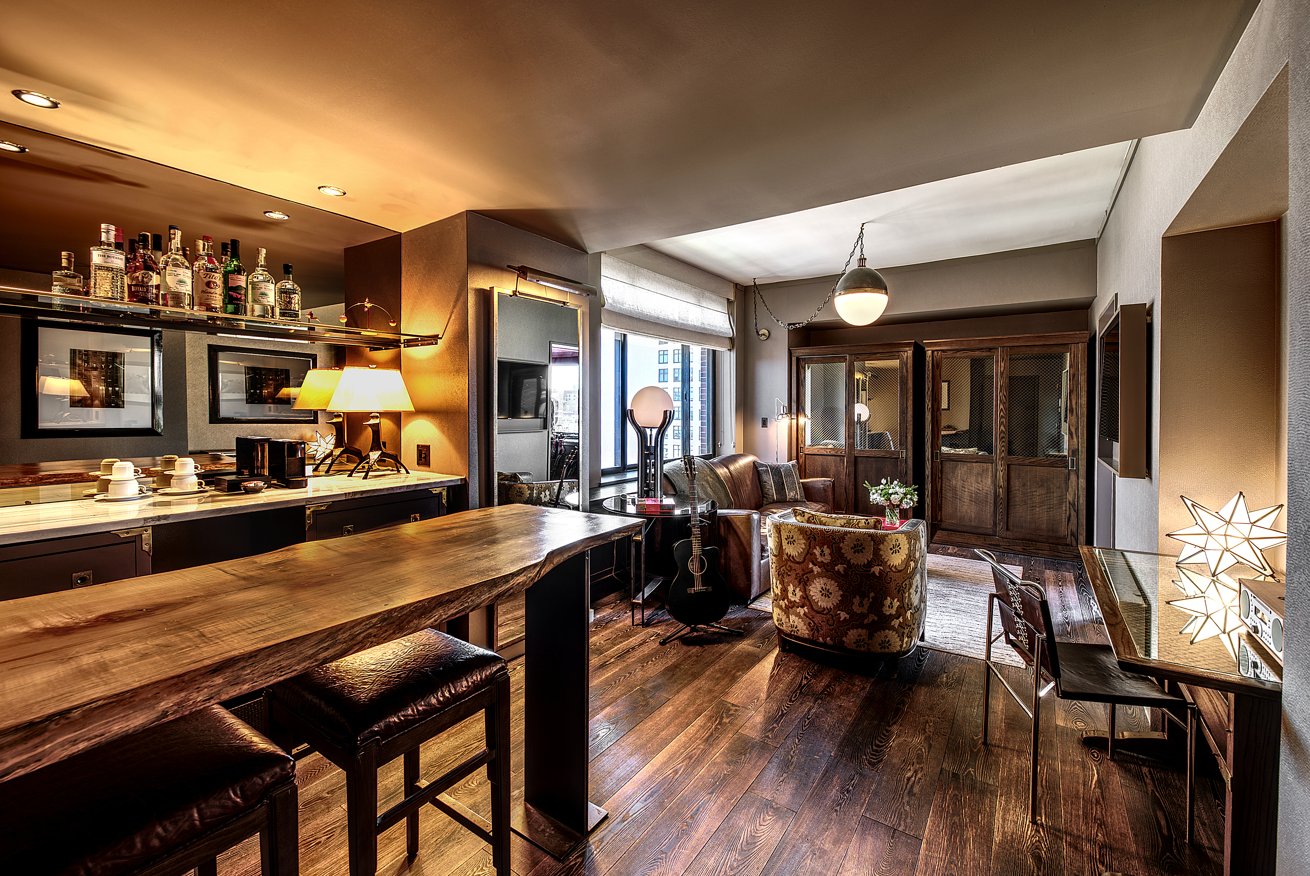 the living room of the grand suite. there is a bar, seating area and a desk