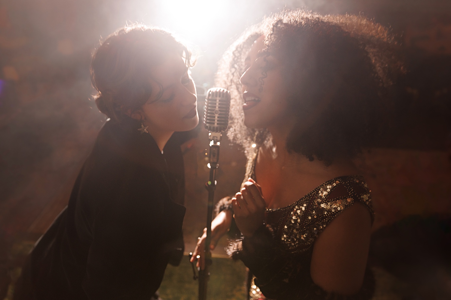 Two women singing into a microphone at Club Room.