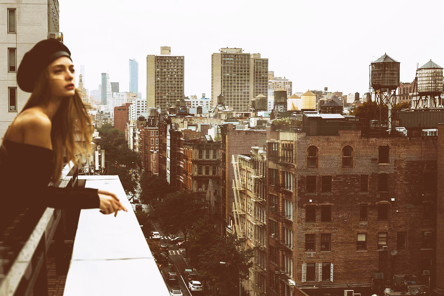 a woman is looking out over a terrace to take in the views of the SoHo neighborhood