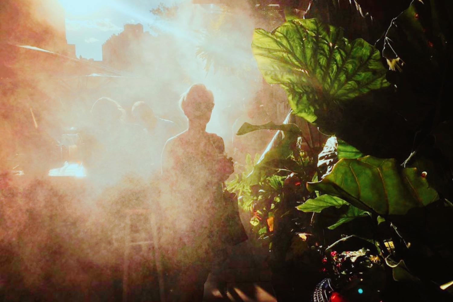 Women walking thru mist on a sunny day at Gilligan's Outdoor Eatery in SoHo, NY.