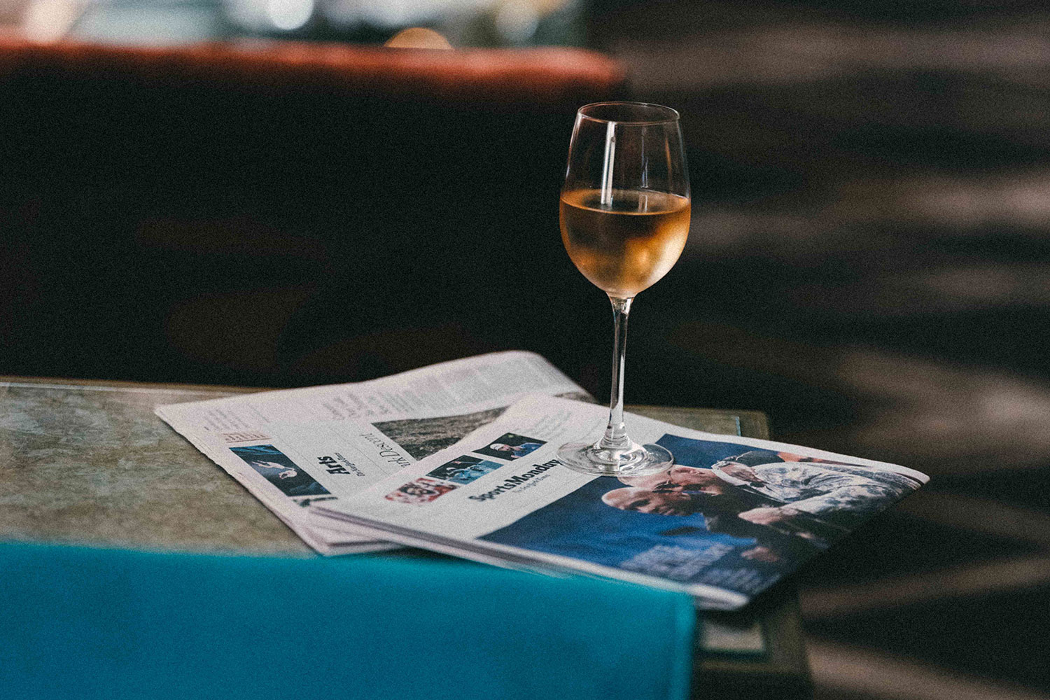 Glass of Wine on Newspapers at Grand Bar & Salon at Soho Grand Hotel.
