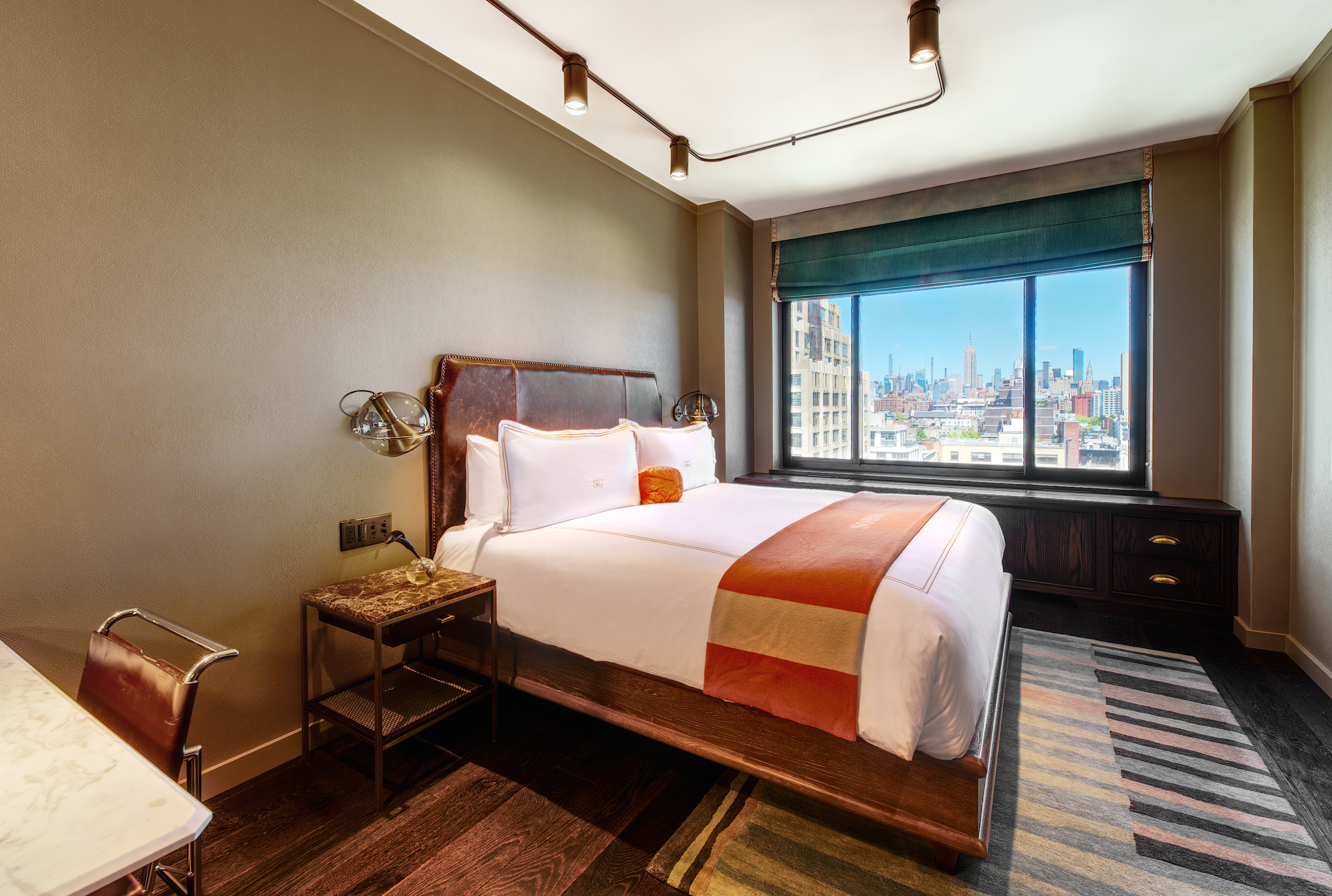 bedroom with a double bed, a desk, a nightstand and a view of midtown manhattan skyline
