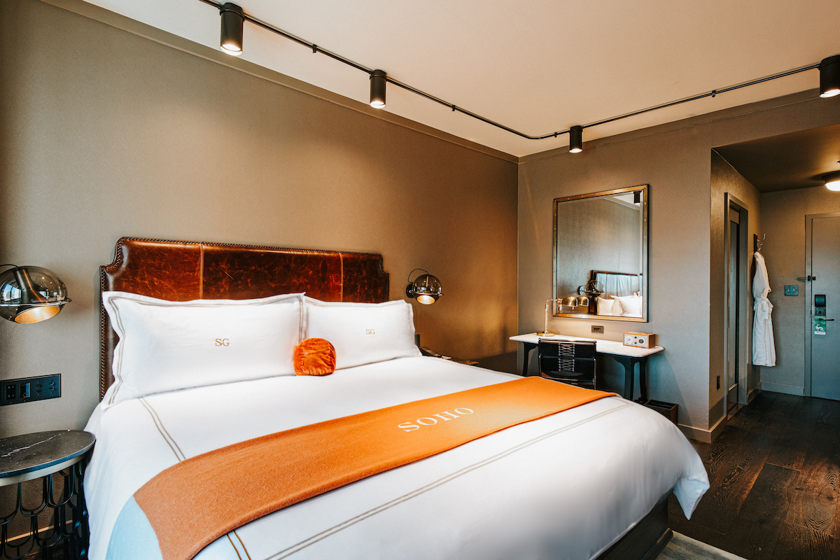 king bed with an orange throw blanket in the grand deluxe king room