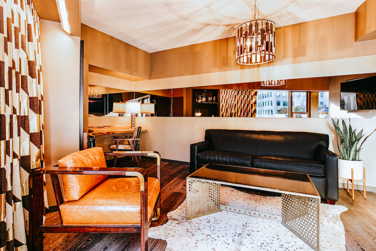 Deluxe Suite Living Area with a leather couch and chair. The interior details are carefully curated