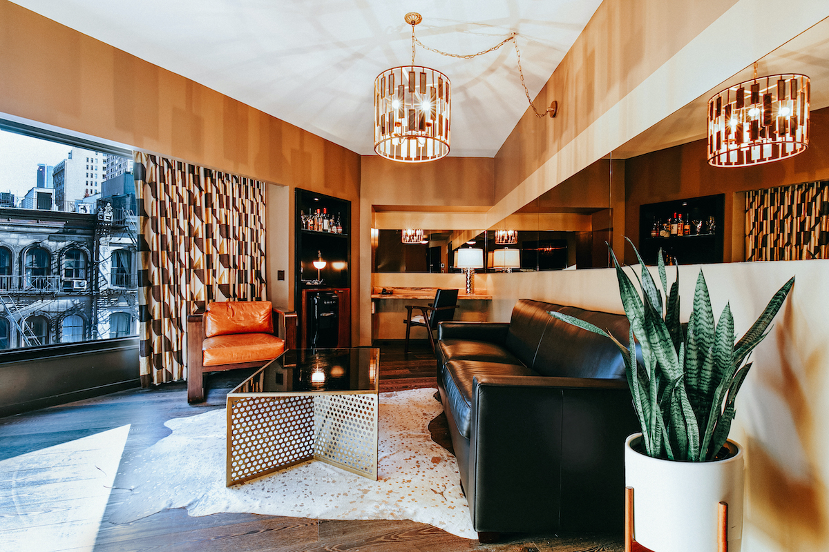 Deluxe Suite Living Area with a leather couch and chair. The interior details are carefully curated