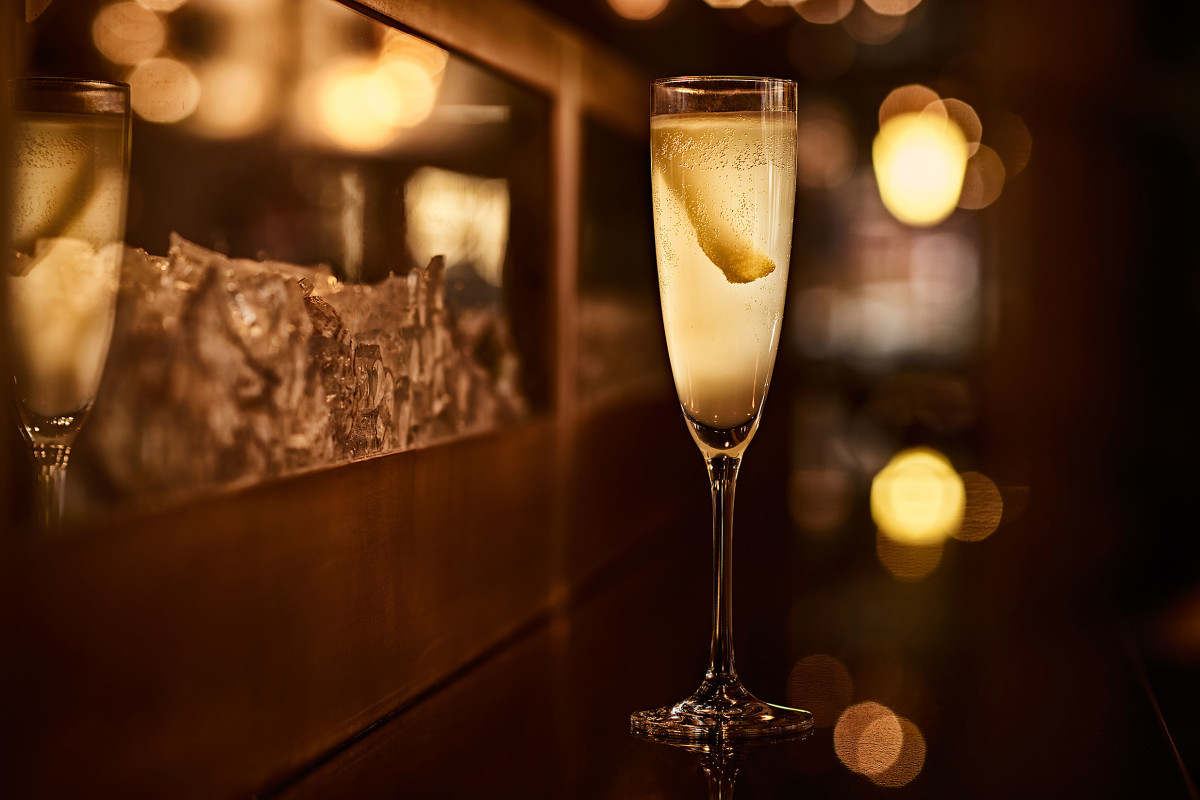 a detail shot of a cocktail in a flute glass with a lemon twist