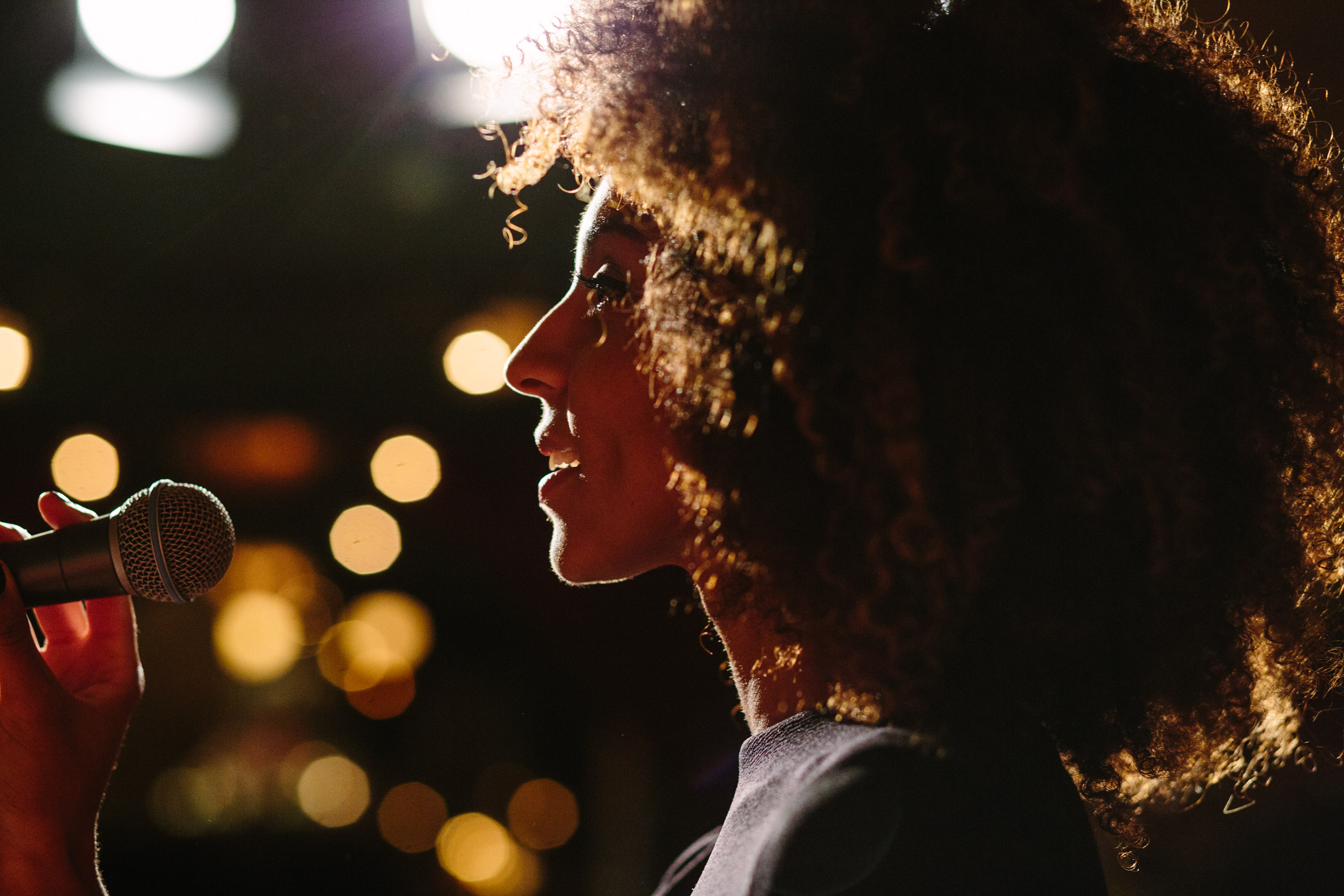 a woman singing soulfully into a microphone