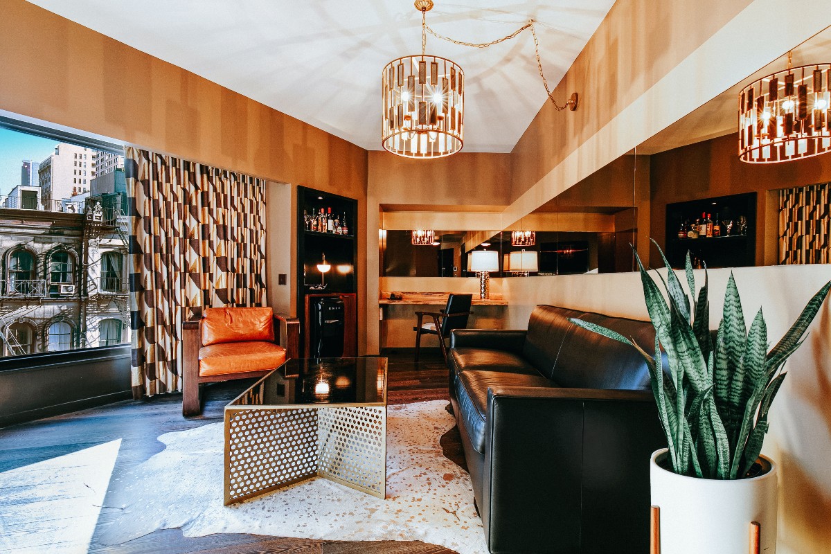 Roxy Deluxe Suite Living Room couch, coffee table, chair, and expansive window with view of TriBeCa.