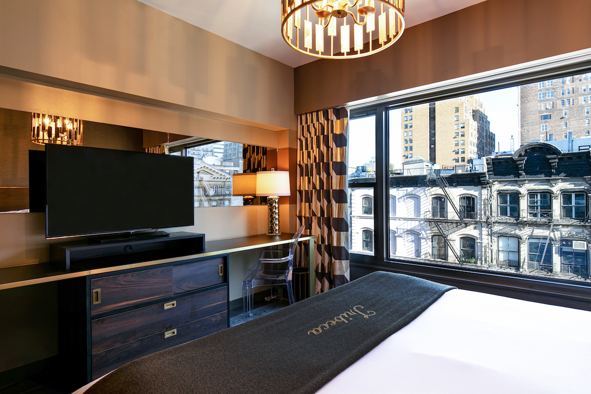deluxe three bedroom suite bedroom with a king bed and a tv