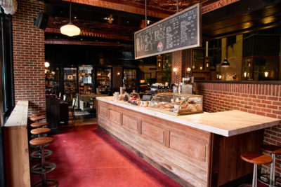 jack's stir brew coffee counter with a pastry case and a black board with specials written on it