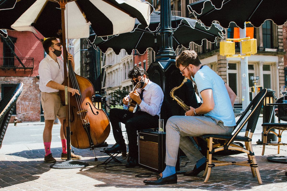 a trio of musicians playing their instruments on the roxy bar terrace