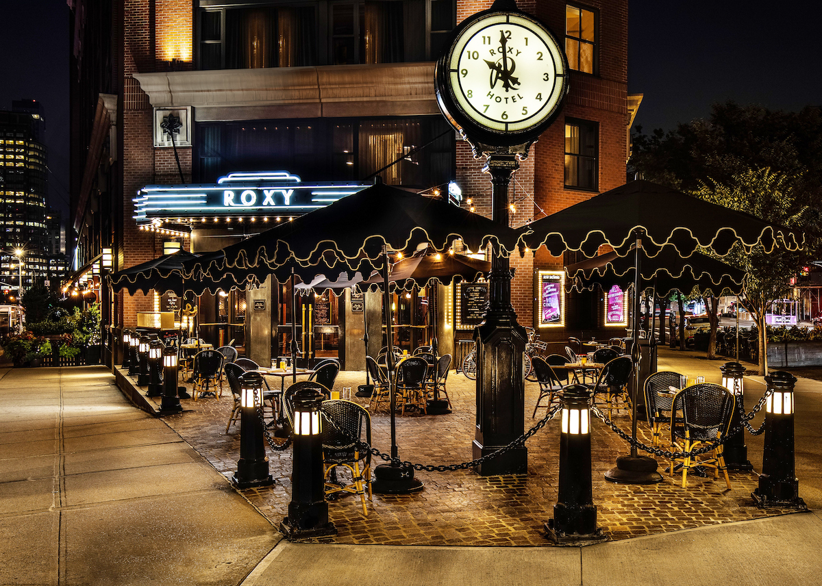 the roxy plaza at night. the building is shown and lit up by neon lights