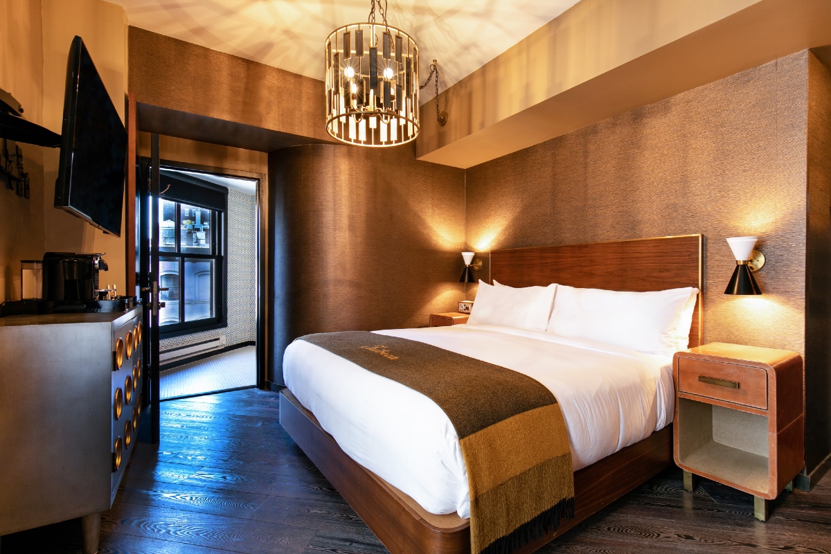King Bed and bathroom entrance of a guest room at Roxy Hotel.