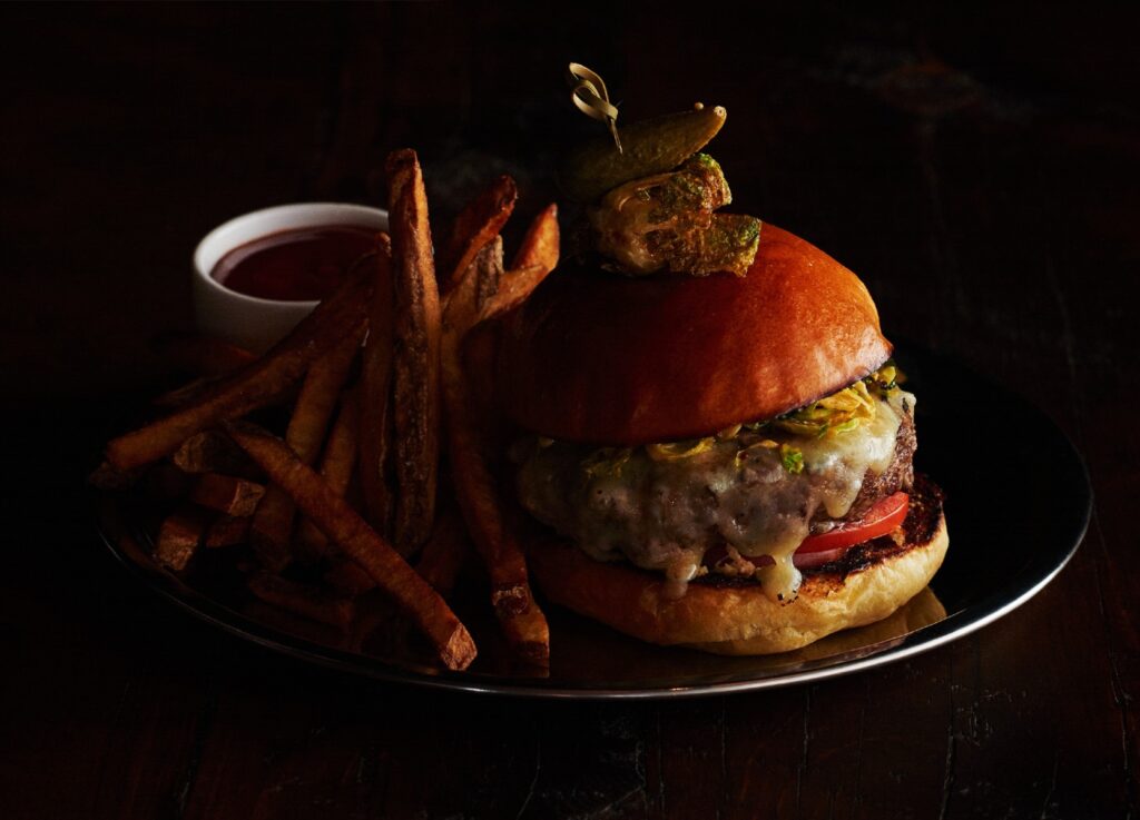 Cheeseburger and fries on a silver platter at Roxy Hotel