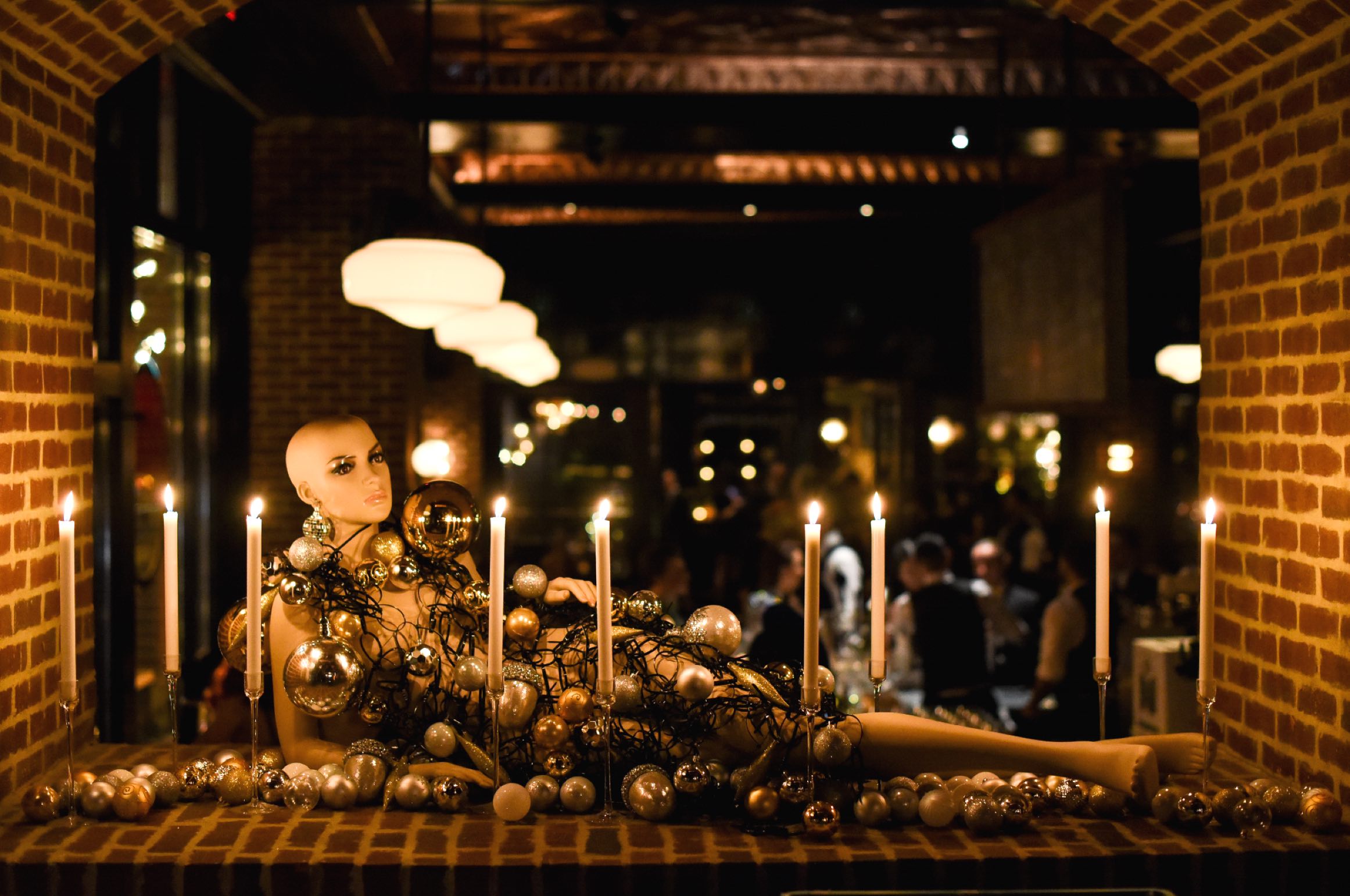 Mannequin laid across Christmas decorations and candles.