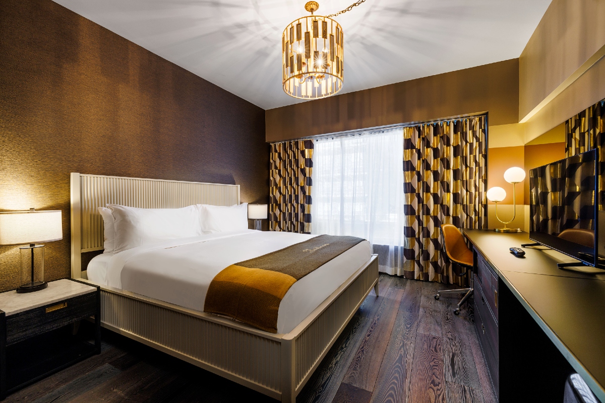 Roxy Hotel Guest Room showing the king bed, chandelier, wood floors, workdesk, side tables and lamps.