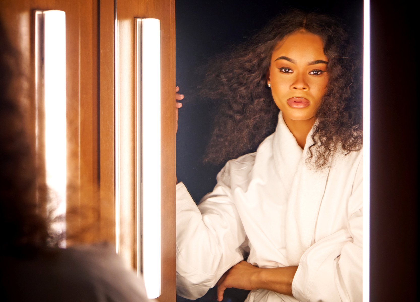 Woman looking into the mirror in a guest room at Roxy Hotel.