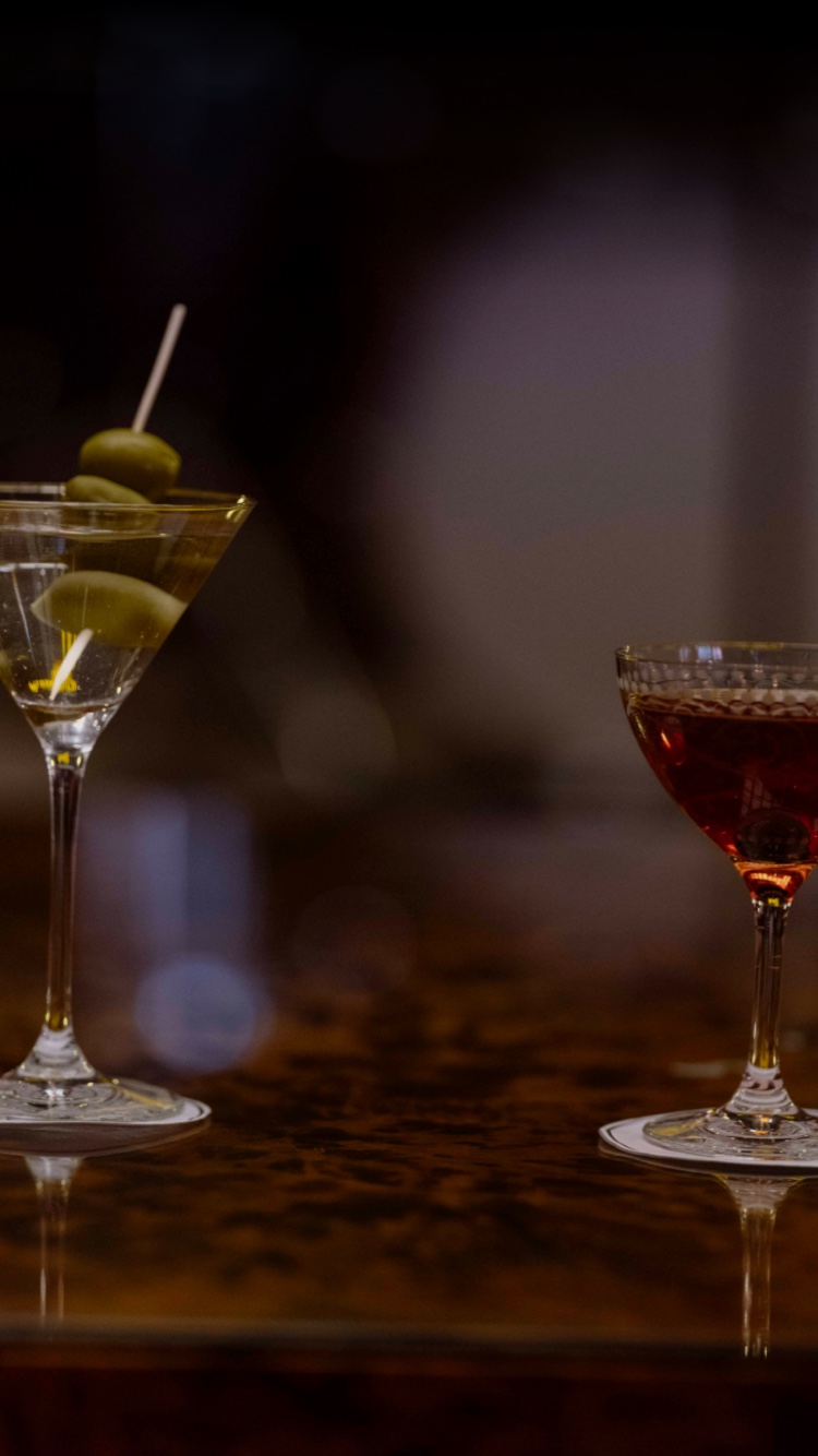 A detail shot of two Roxy Bar cocktails. one has three olives in it