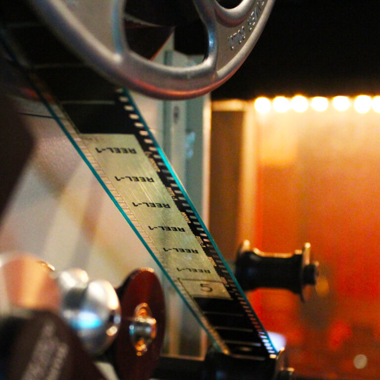 a detail shot of 35MM film being fed through the projector