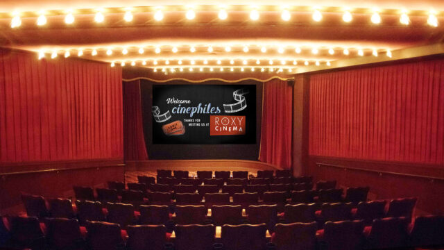 the interior of the roxy cinema new york's screening room with classic red accents. The screen reads "Welcome Cinephiles"